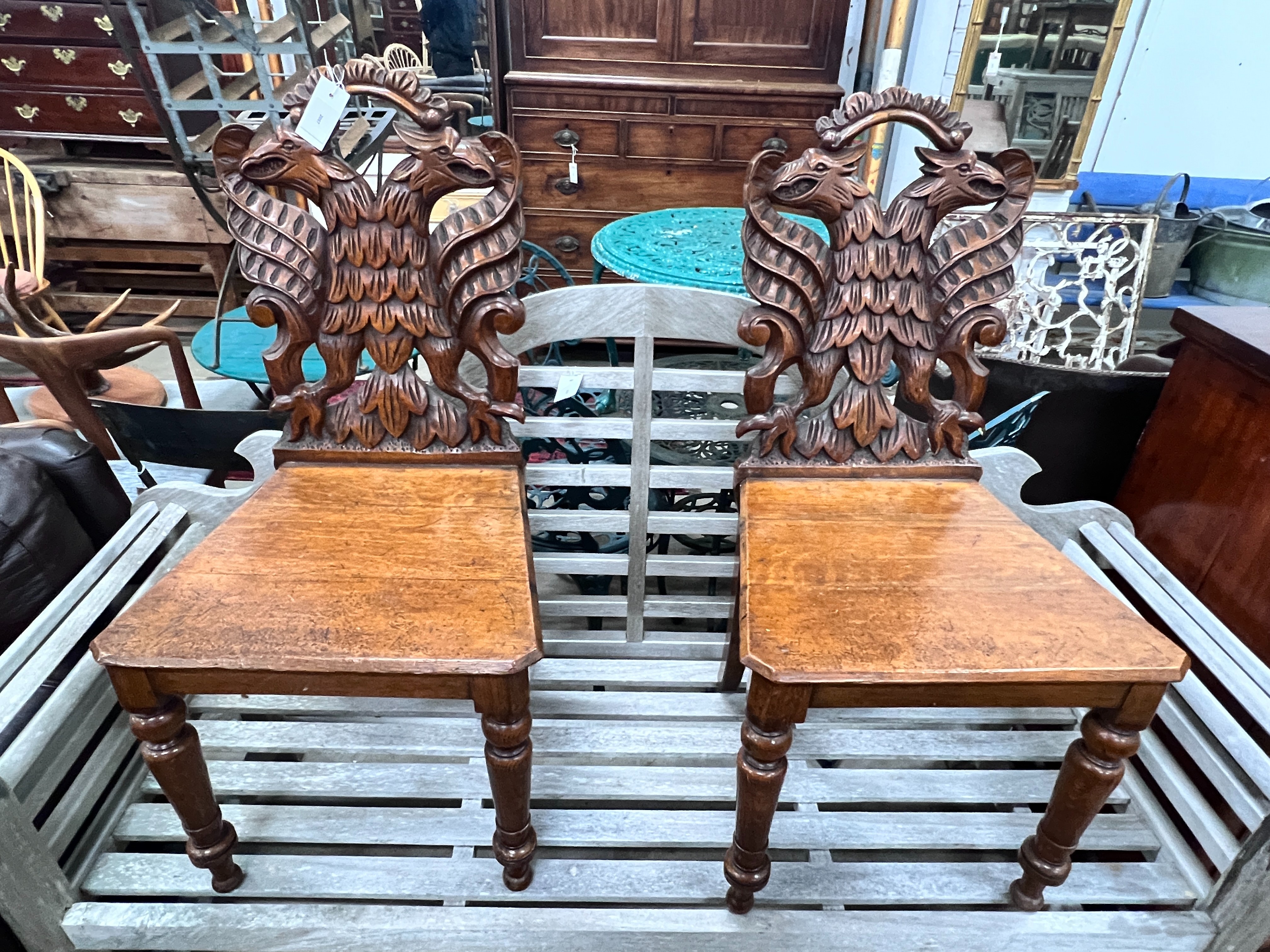 A pair of Victorian carved oak hall chairs with carved twin eagle backs, width 44cm, depth 40cm, height 90cm